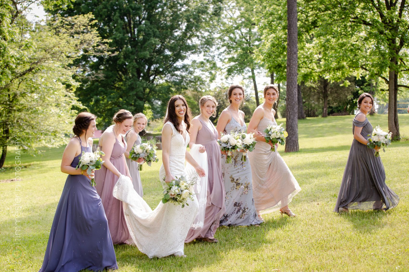 Chloe, the bride, and her bridesmaids walk the property of Barn at Valhalla in Chapel Hill, NC.