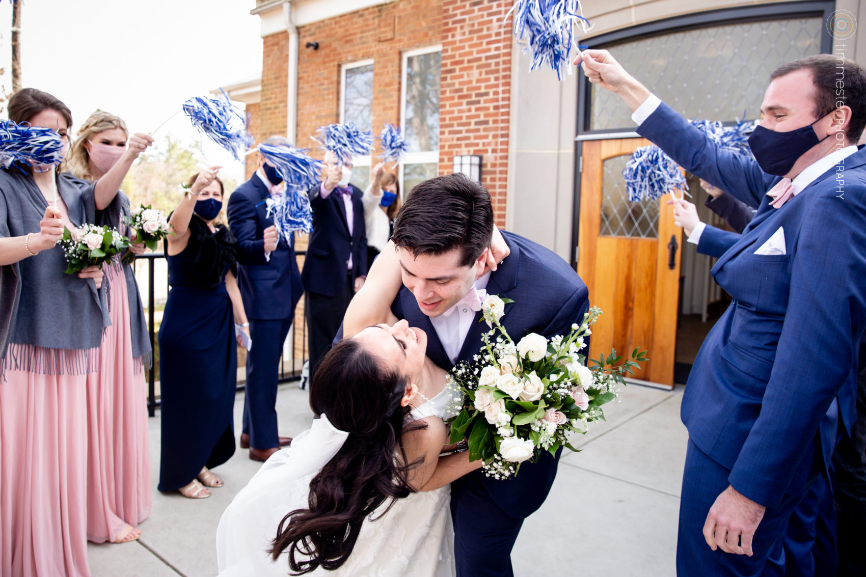An exit with Duke University pom poms from their Chapel Hill church wedding